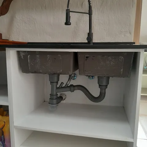 Double kitchen sink with modern tap and tidy under-sink plumbing
