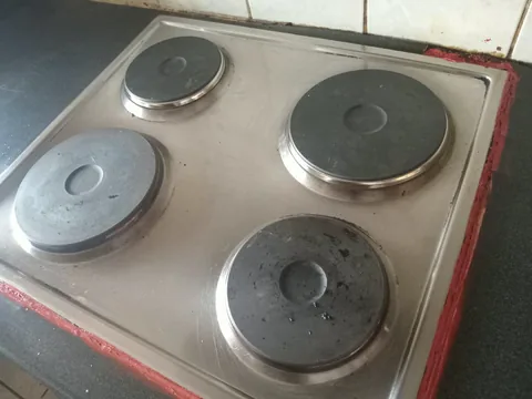 Four-plate electric hob set into a dark kitchen countertop after electrical installation
